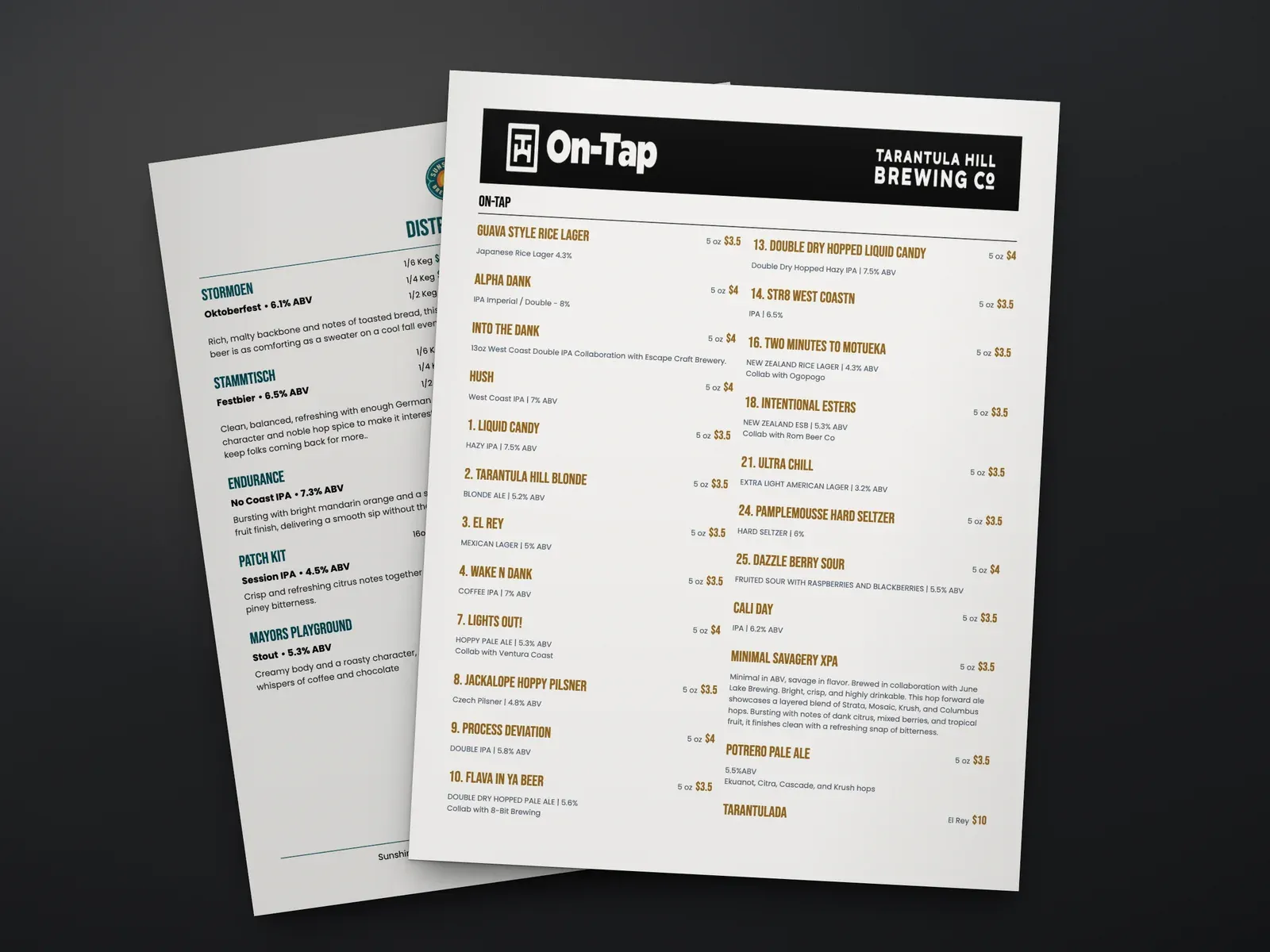 A printed Tarantula Hill Brewing on-tap menu in two columns with sizes and prices, lying on a dark table over a second printed menu