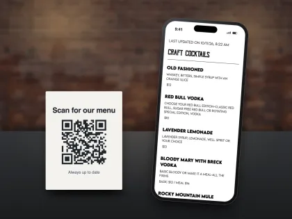 A Scan for our menu table card with a QR code next to a phone showing the cocktail menu it opens